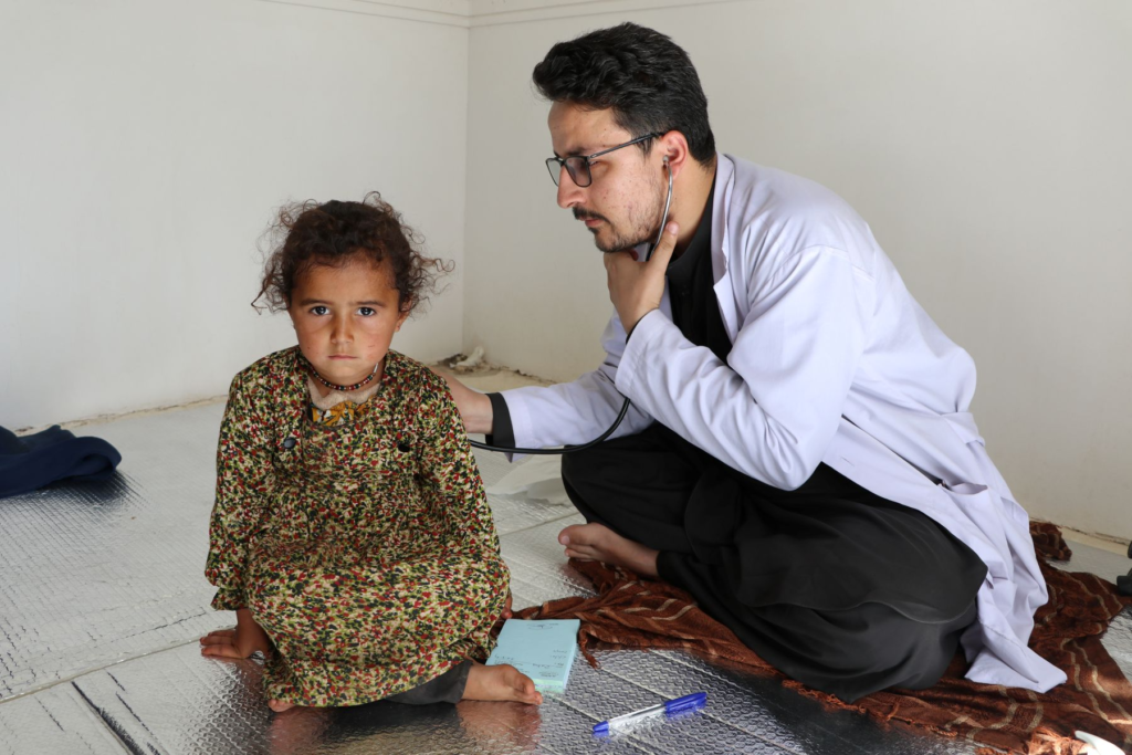 Doctor using a stethoscope to examine a young girl during a Be Team International Cure Hospital mobile clinic in Afghanistan