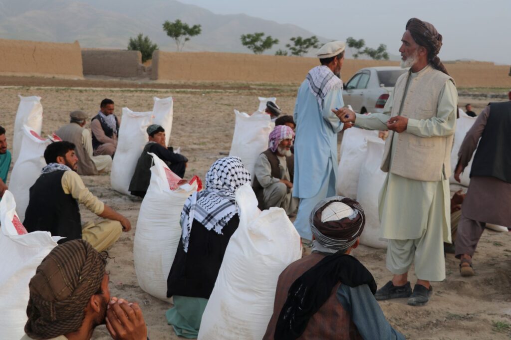 Be Team International Cure Hospital team member addressing beneficiaries receiving food supplies at a medical camp in Baghlan, Afghanistan
