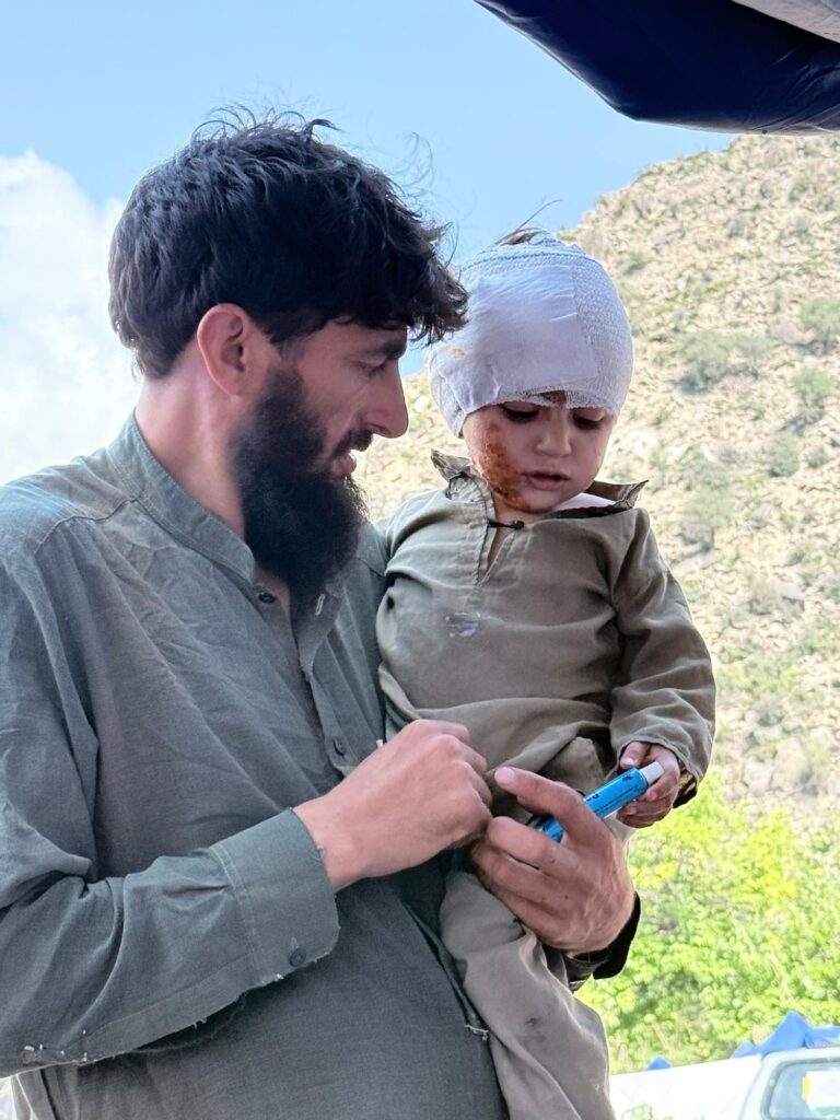 Father holding his injured toddler son at a Be Team International Cure Hospital medical camp in Kunar Province, Afghanistan