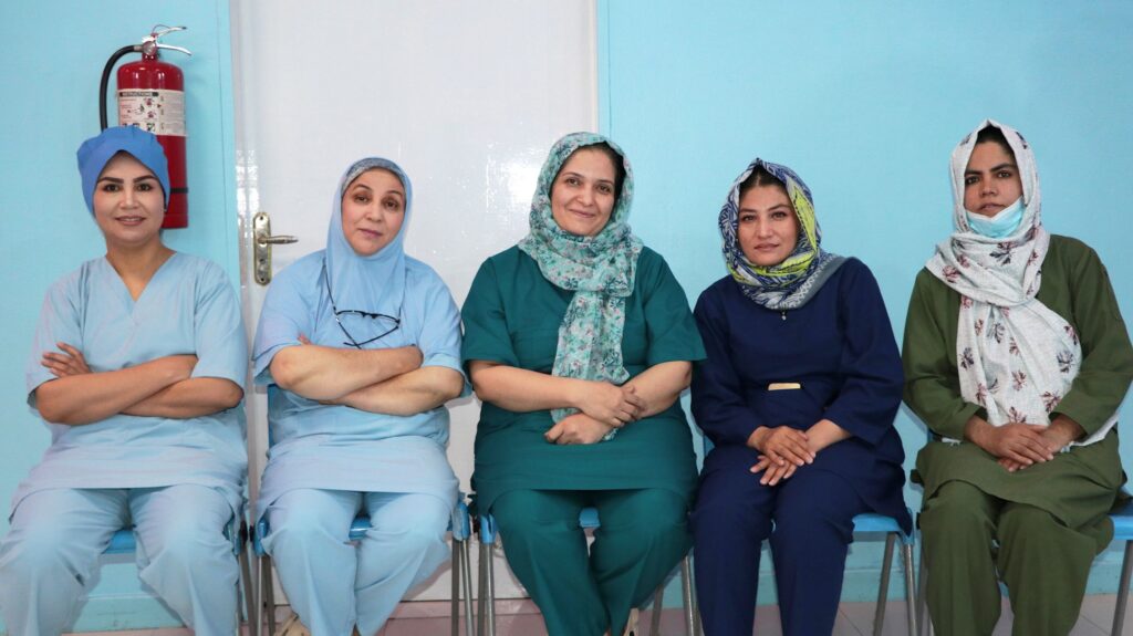 Five female fistula surgery team members seated together at Be Team International's Cure Hospital in Kabul, Afghanistan